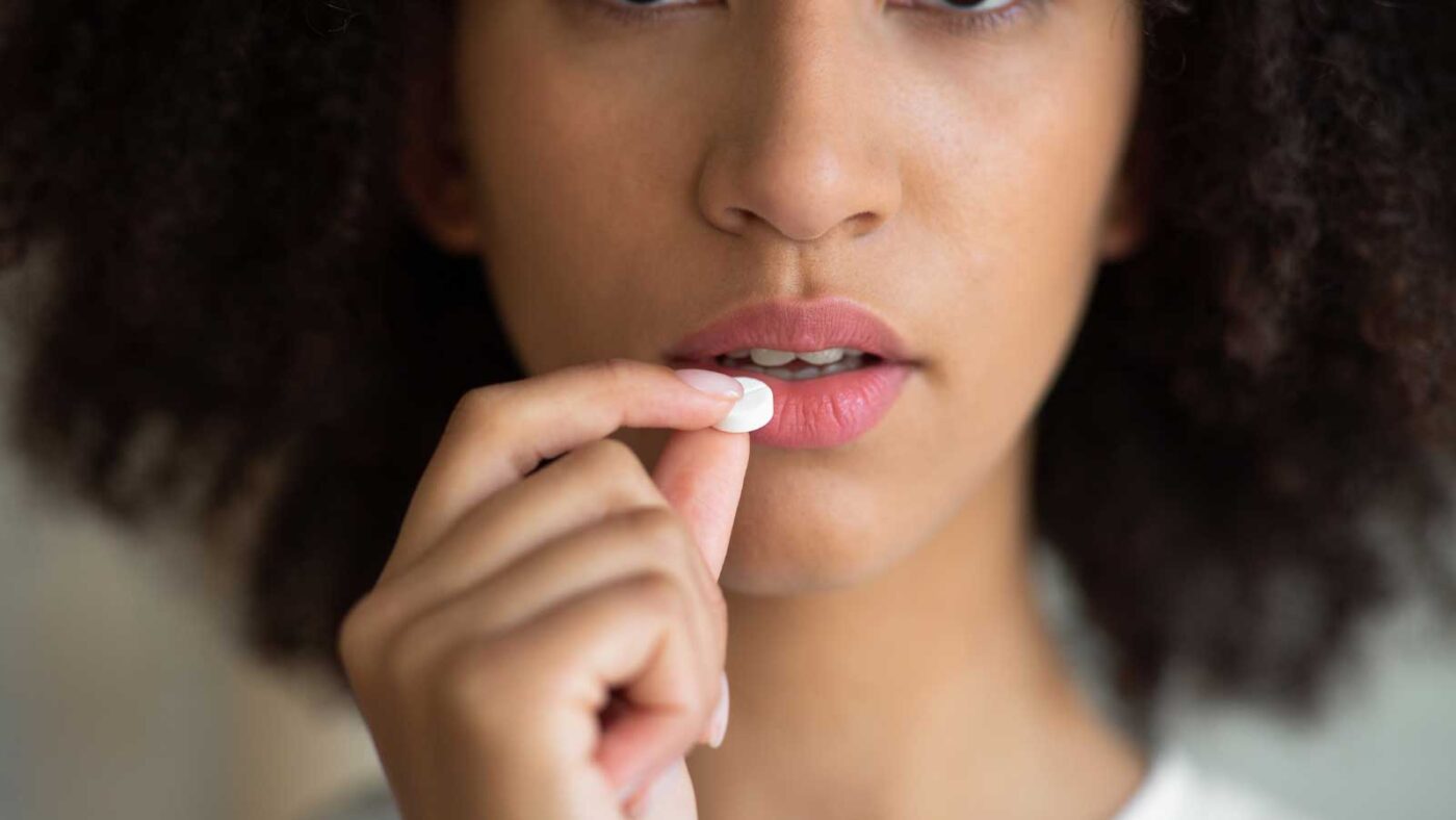 Woman taking an oral sedation pill