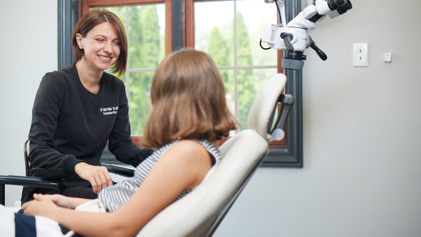 A dentist warmly consulting with a young patient in a modern clinic