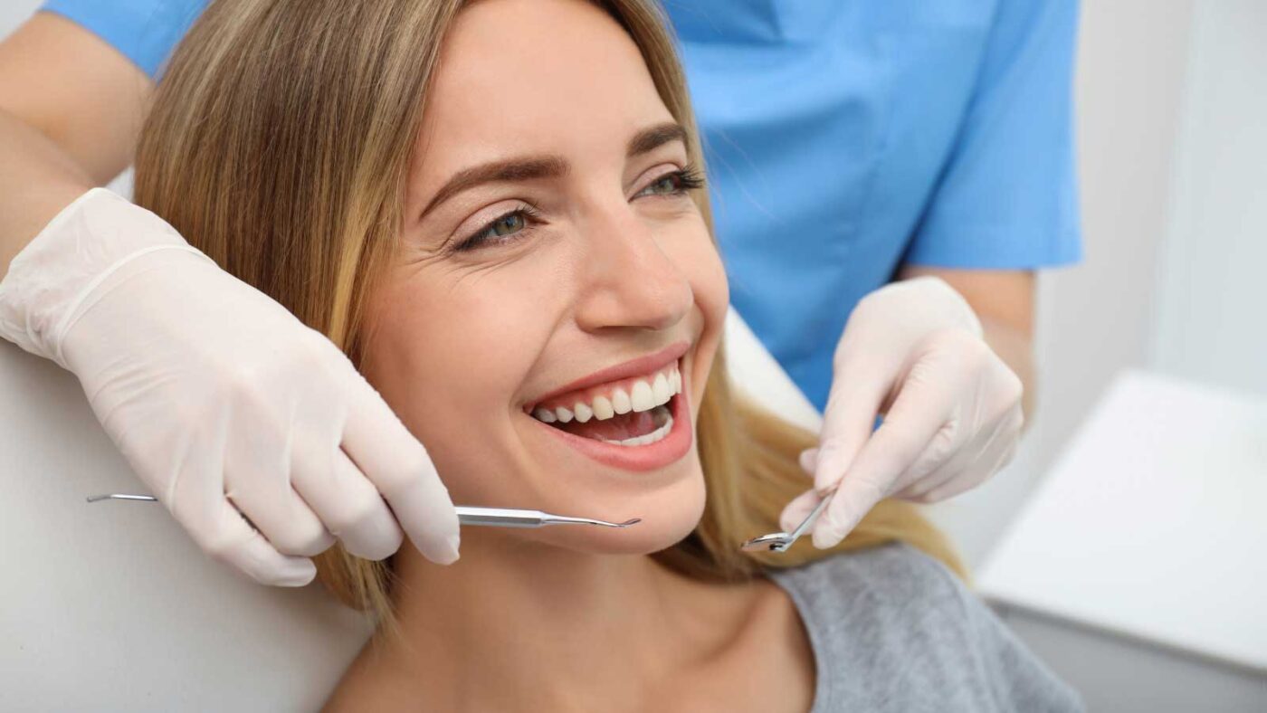 Smiling patient receiving a dental check-up from a professional