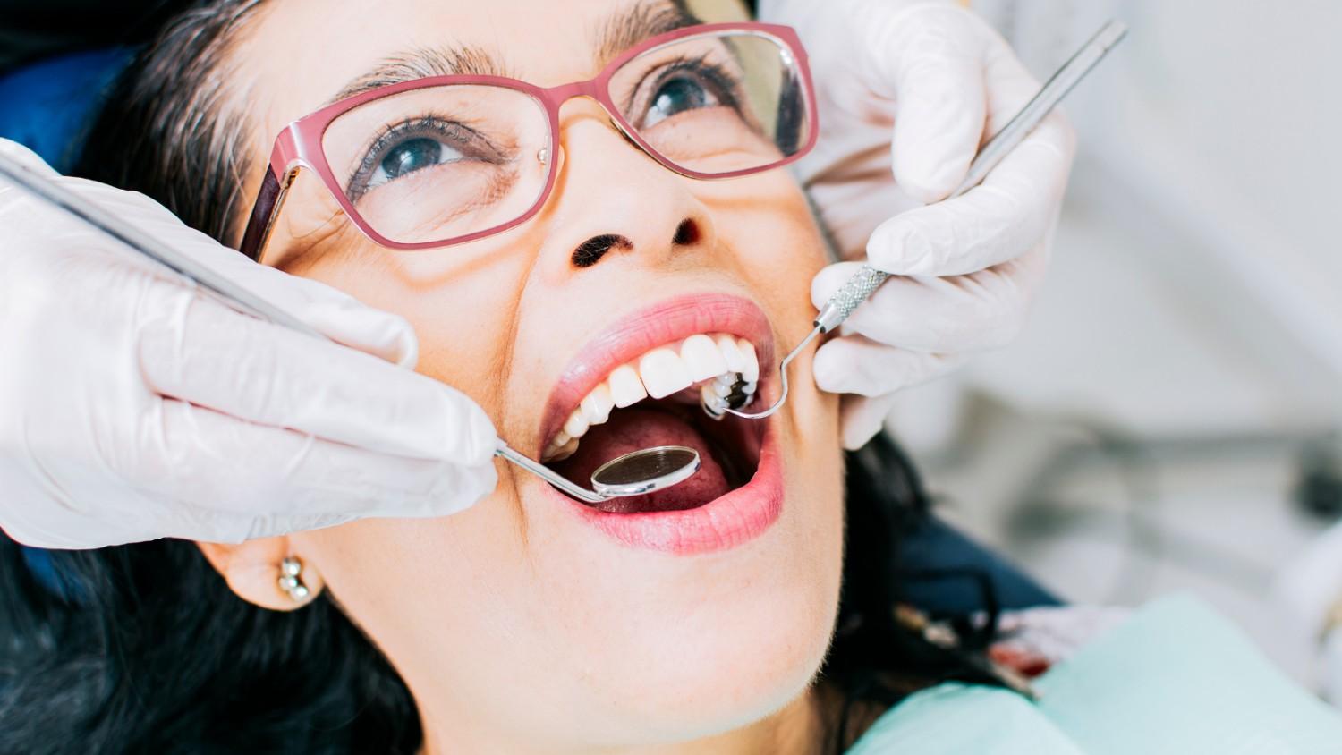 Womanreceivingadentalcheck-upwithdentalinstrument
