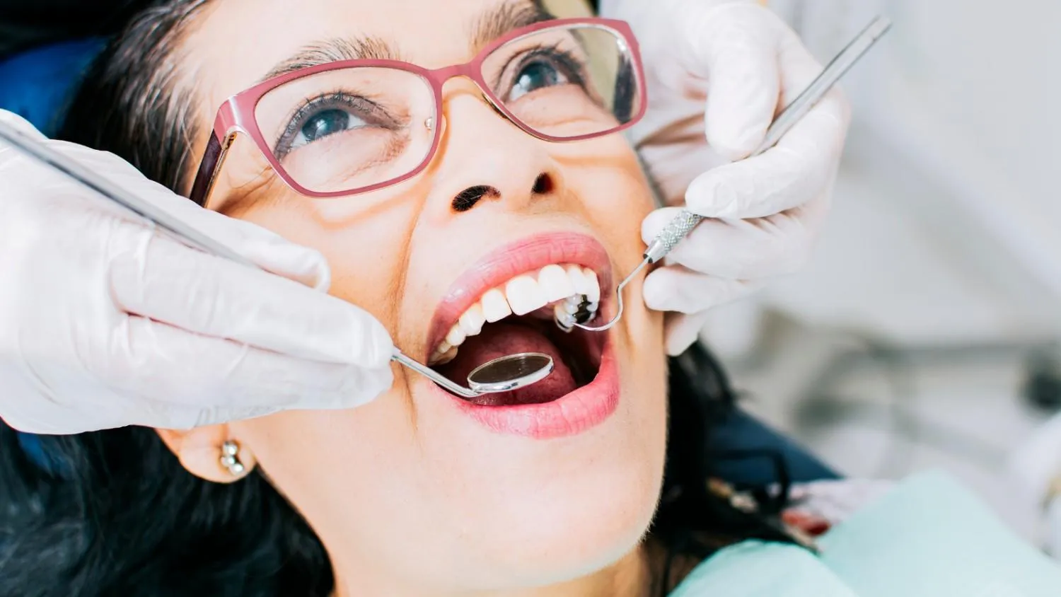 Womanreceivingadentalcheck-upwithdentalinstrument
