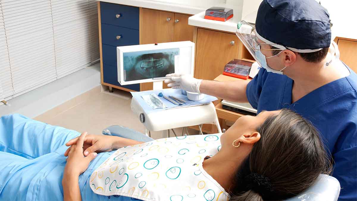 Dentist showing a dental X-ray to a patient in the clinic.