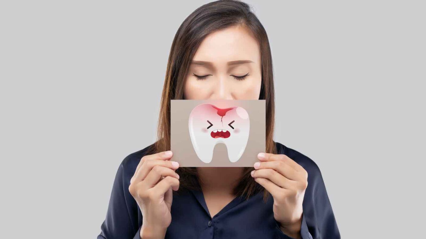 Woman holding cartoon of aching tooth