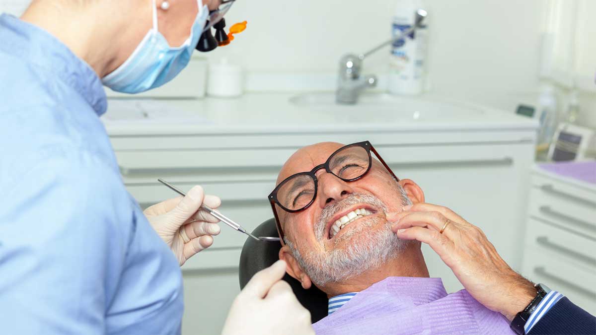 A dentist performing a root canal on a senior patient.