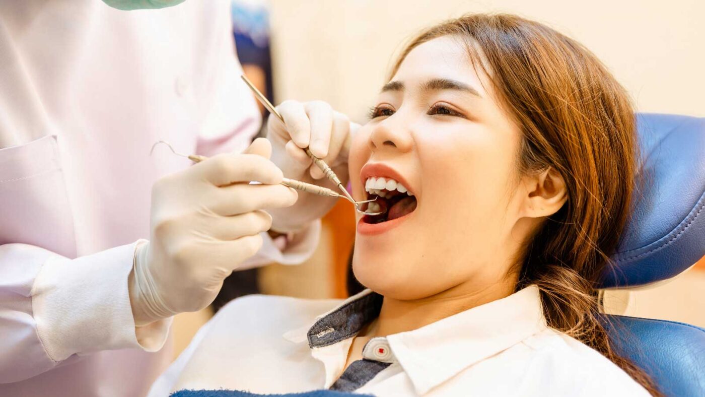 Dentist examining a patient's teeth during a check-up.