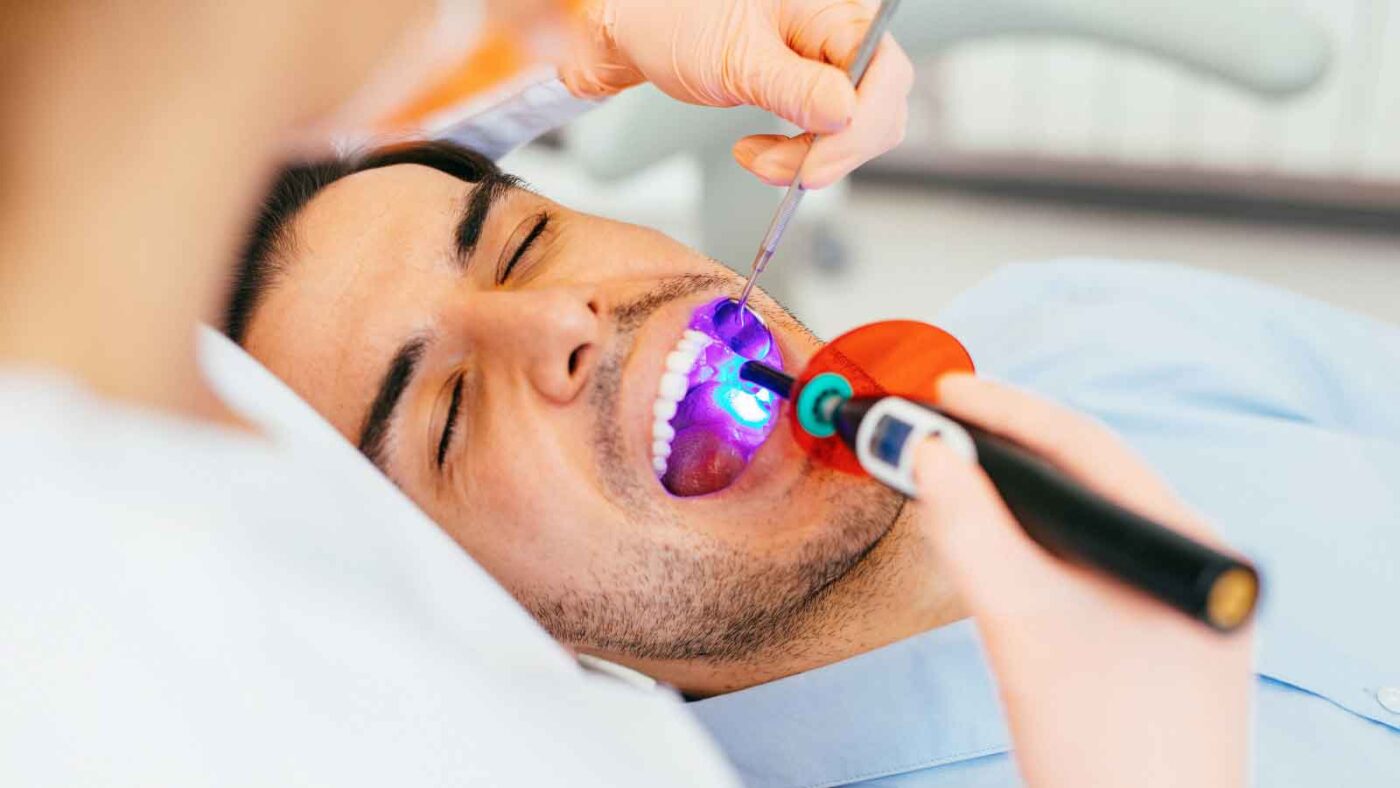 Man receiving dental light treatment