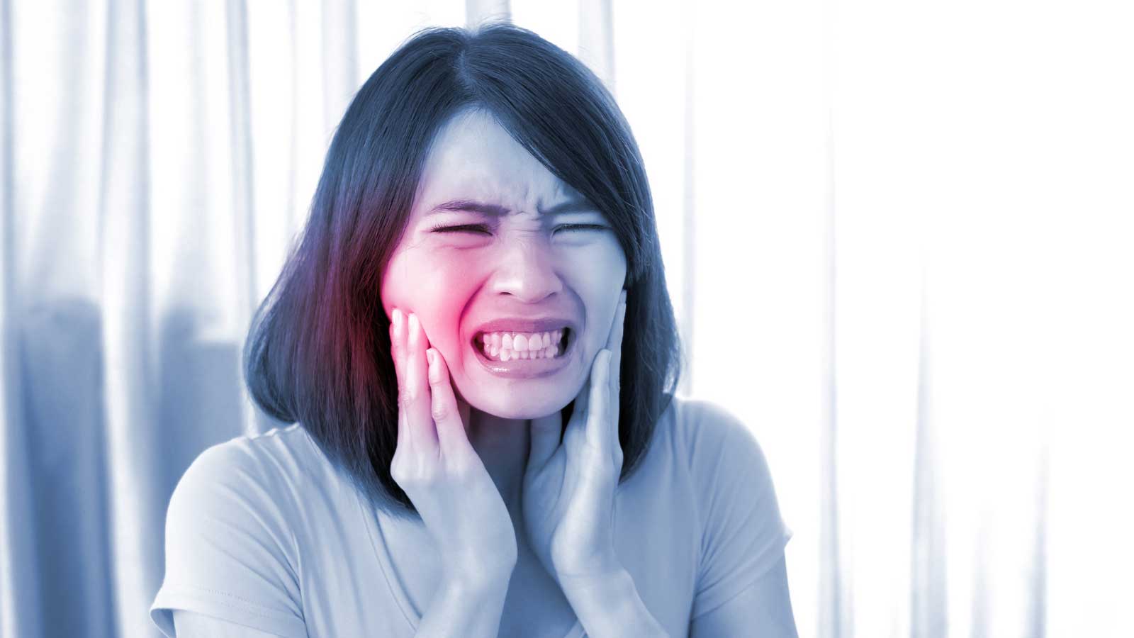 Woman-holding-her-jaw-in-pain-from-a-toothache