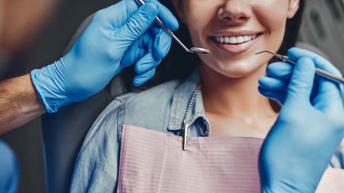  A dentist examining a patient's teeth with dental tools.