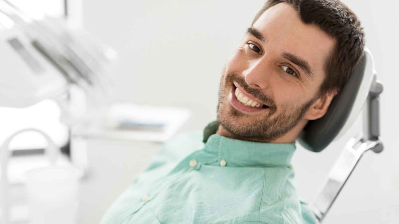 A man smiling confidently in a dental chair