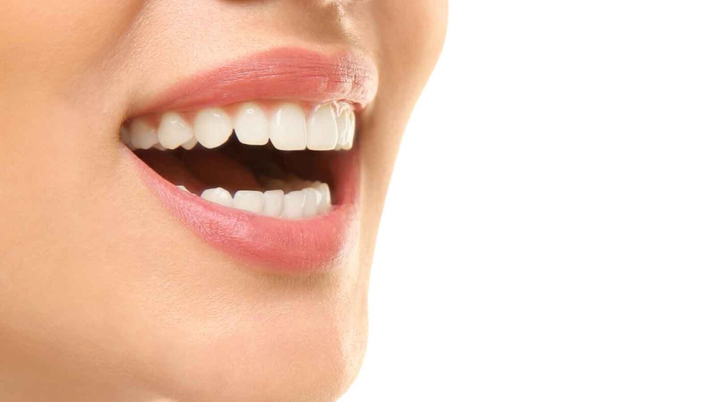 Close-up of a person smiling with healthy, white teeth.