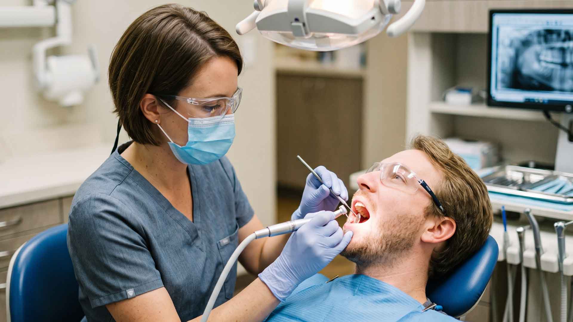Patient receiving endodontic treatment while seated in a dental chair.