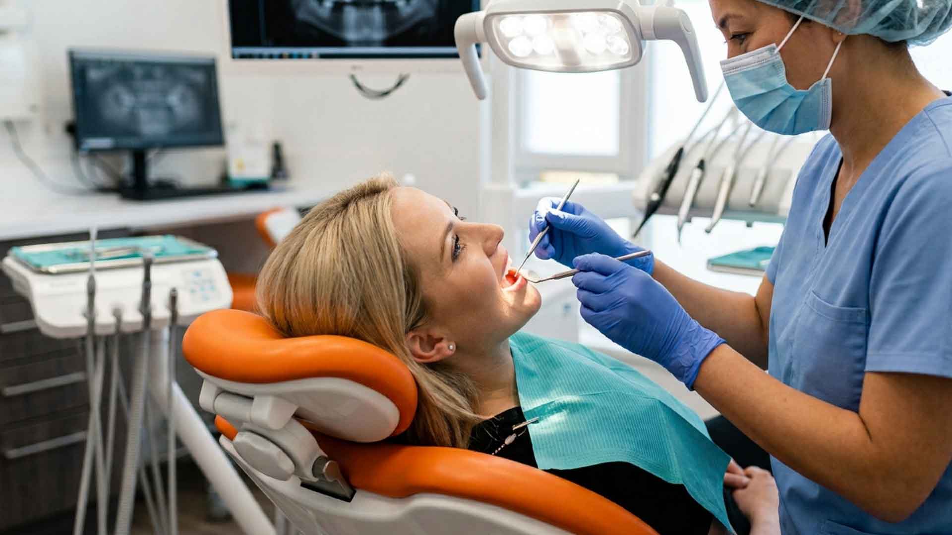Dentist examining a patient’s tooth during a dental appointment.

